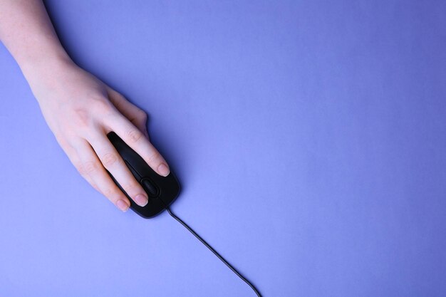 Hand over a keyboard, hovering over a mouse, with a digital clock displaying 