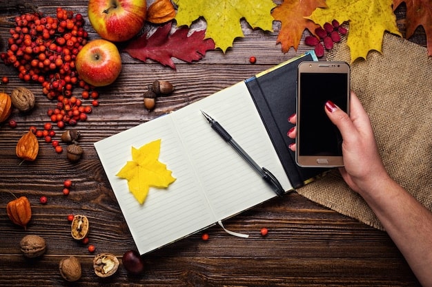 An open planner on a wooden desk. The pages are filled with colorful notes, stickers, and neatly written appointments. A hand is seen writing in additional notes using a stylish pen.