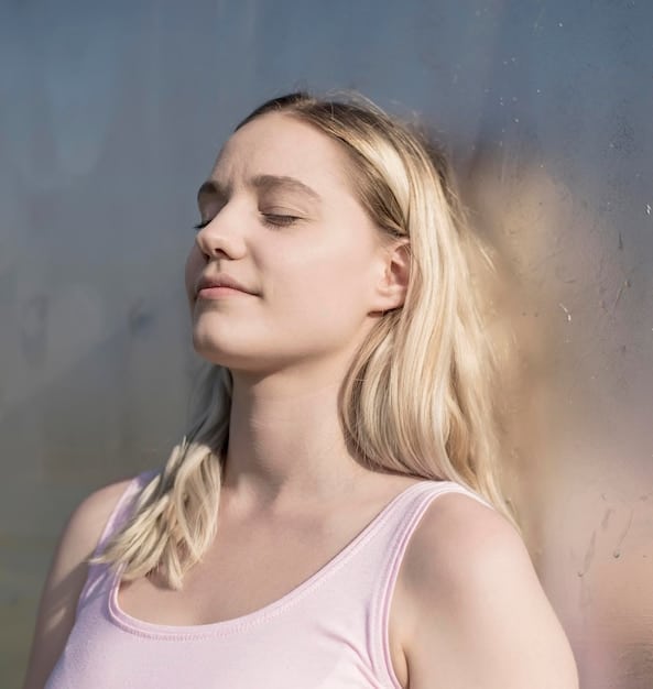 A close-up of a person's face in serene meditation, with gentle sunlight illuminating their closed eyes, emphasizing inner peace and concentration.