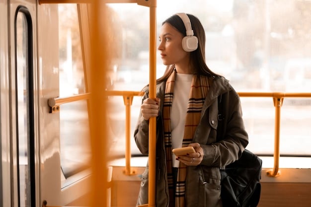 A person on a train, wearing noise-canceling headphones and comfortably reading a book, surrounded by other passengers in the background.