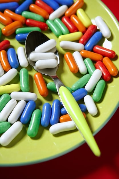 A close-up shot of various supplement capsules and tablets arranged on a lab bench, next to scientific equipment like test tubes and beakers. The lighting is bright and sterile, emphasizing the scientific and analytical nature of supplement evaluation.